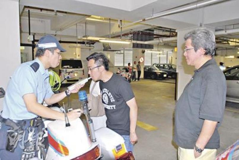 肇事私家車司機(中)在律師(右)陪同下接受酒精呼氣測試,證實未有酒後駕駛。(劉友光攝) 肇事私家車司機(中)在律師(右)陪同下接受酒精呼氣測試,證實未有酒後駕駛。(劉友光攝)