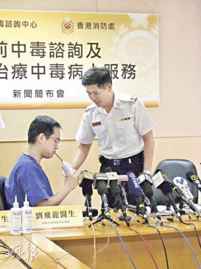 醫管局中毒諮詢中心副顧問醫生陳志強(左)示範,病人須坐着自行飲用50克「萬能解毒劑」。(林景輝攝) 醫管局中毒諮詢中心副顧問醫生陳志強(左)示範,病人須坐着自行飲用50克「萬能解毒劑」。(林景輝攝)