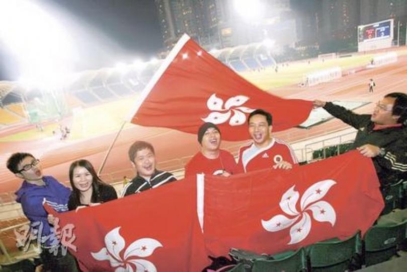 佐敦（戴帽者）與其他港足球迷，昨晚持區旗在小西灣球場支持港足打熱身賽。他們早前幾經辛苦才從足總處爭取到20張首場賽事入場券，但由於仍有大批球迷無票，他們正計劃派代表明日到廣州花都球場外排隊，看看是否仍有門票出售。（林振東攝）