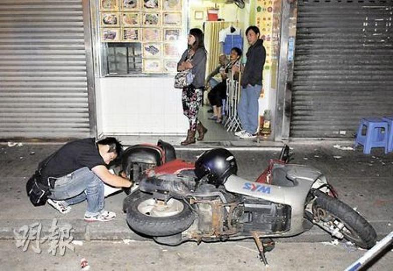 深水埗黃竹街泰式食肆有食客爭執，警員檢查被推倒電單車損毁情况。（蔡方山攝）被捕男子帶上警車時仍粗口連篇罵個不休。（蔡方山攝）