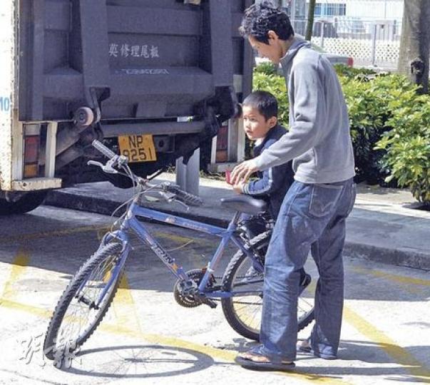 姓許父子騎乘一輛單車途經隆亨邨，與另一名騎單車女子相撞，父子並無受傷，協助警方調查後離去。（蘇偉明攝）
