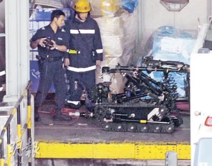 警方出動拆彈機械人檢查冒出煙火的郵包，郵政署事後透露出事郵包內載着3至4枚電池，並不涉及爆炸品，又指電池屬於禁止郵寄物品。（蘇偉明攝）