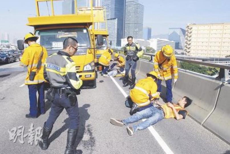 觀塘繞道的泥頭車串燒工程車意外中,兩名工人走避不及受傷,躺在路邊等候救援。(劉友光攝)風琴箭嘴車司機(右二)及載水箱工程車司機(左一)向警員講述事發經過。(劉友光攝)(明報製圖) 觀塘繞道的泥頭車串燒工程車意外中,兩名工人走避不及受傷,躺在路邊等候救援。(劉友光攝)風琴箭嘴車司機(右二)及載水箱工程車司機(左一)向警員講述事發經過。(劉友光攝)(明報製圖)