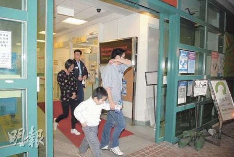 4個月大女嬰送院搶救後不治，其父母及兄長被警方帶走協助調查，母親離開醫院時滿臉淚痕。（曾立本攝）