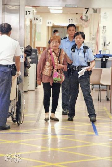 一名涉案的金髮老婦需送院檢驗，事後登上警車返署協助調查。（屈俊樂攝）涉案女子在毆鬥中受傷，送仁濟醫院治理後，被警員帶返警署調查。（屈俊樂攝）