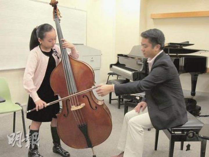 9歲女生麥晞靖(左)剛贏得柏林低音大提琴9至10歲組別冠軍,演藝學院老師鄭景聰(右)說,平日斯文的晞靖,一到比賽便施展渾身解數,充滿音樂感。(彭美芳攝) 9歲女生麥晞靖(左)剛贏得柏林低音大提琴9至10歲組別冠軍,演藝學院老師鄭景聰(右)說,平日斯文的晞靖,一到比賽便施展渾身解數,充滿音樂感。(彭美芳攝)