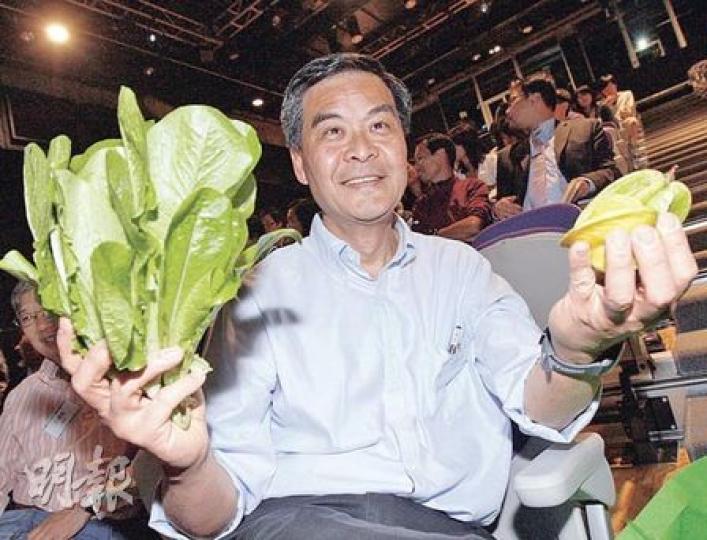 行政會議召集人梁振英昨早在家中摘下一些親手種植的菜和楊桃，送贈予保育人士朱凱迪。（李紹昌攝）