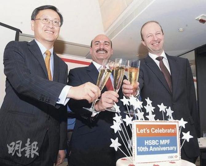 強積金「一哥」匯豐保險總監朱永耀（左）和匯豐保險集團（亞太）主席兼行政總裁湯德信（中）等喝香檳和切蛋糕，慶祝匯豐在強積金成立十周年的前夕推出新產品。（劉焌陶攝）