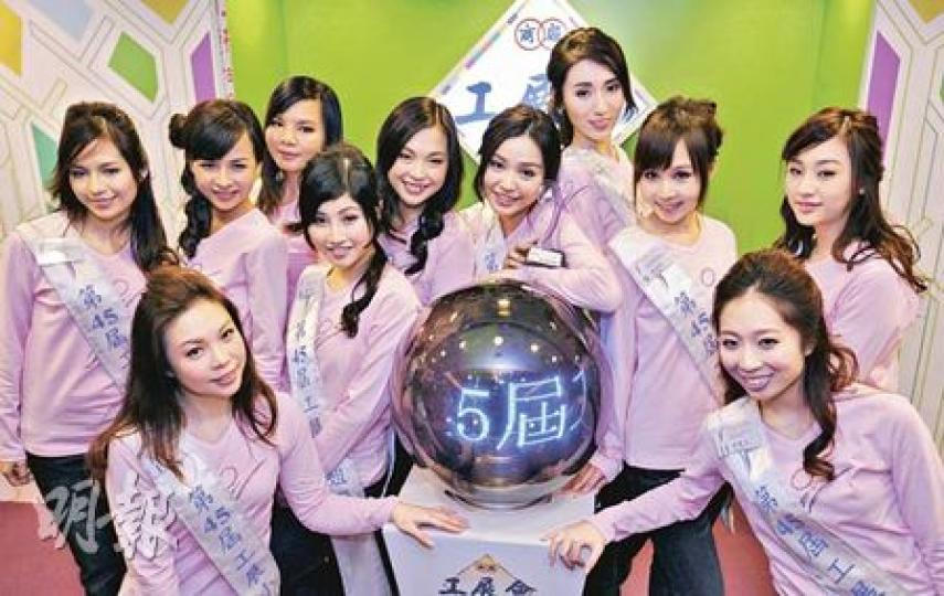 第45屆工展會下周六開幕，除了以超低價貨品吸引市民，一年一度工展會小姐選舉亦是行內盛事，昨日11名來自不同公司的候選佳麗首度亮相，由右五的黃穎君（中間臂擱鐵球者）奪得「最合眼緣佳麗獎」。（朱永倫攝）