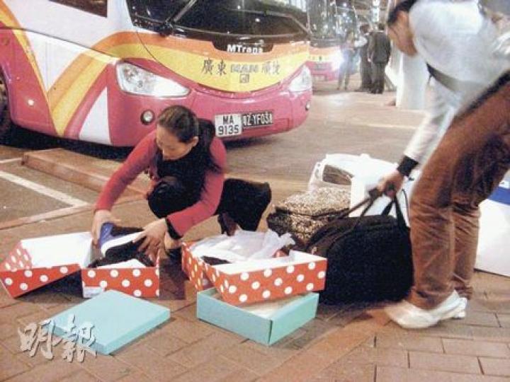 滿載而歸的內地客，從深圳灣口岸進入深圳境前，先將物品包裝拆去，避免被內地海關徵稅。（明報記者攝）