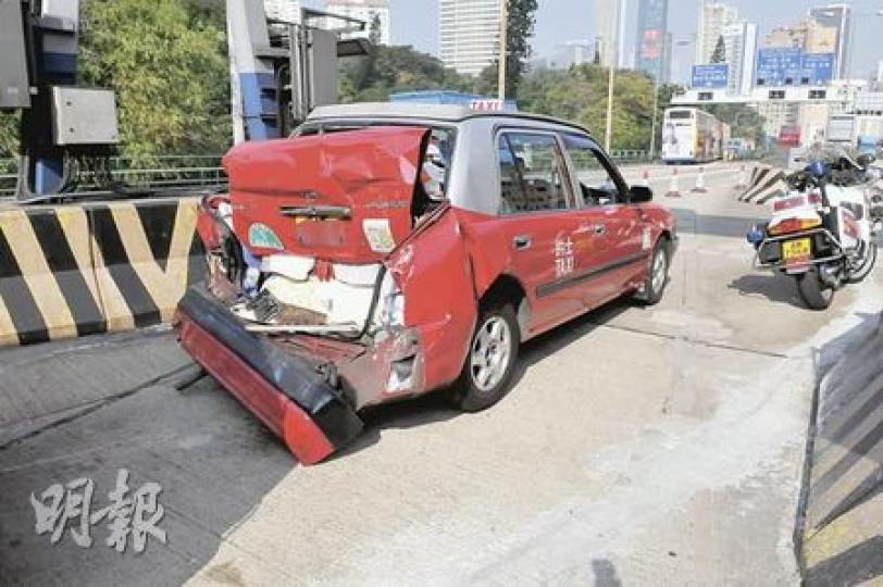 被危險品貨車撞尾之的士，車尾箱被撞至摺曲，車上乘客無受傷，的士司機腰部受輕傷。（林錫禮攝）一輛載有危險品的貨車在香港仔隧道內猛撼的士，其間流出大量懷疑為天拿水的揮發性液體。圖為意外後貨車移出隧道外候查。（林錫禮攝）