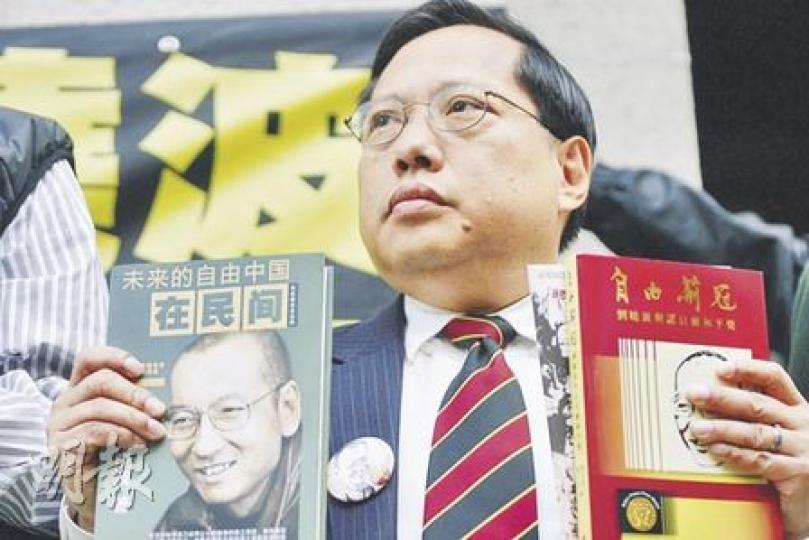 何俊仁表示此行的目標，就是要高舉劉曉波在《零八憲章》提倡的人權、自由等普世價值。圖為他展示劉曉波的文集等書。（郭慶輝攝）