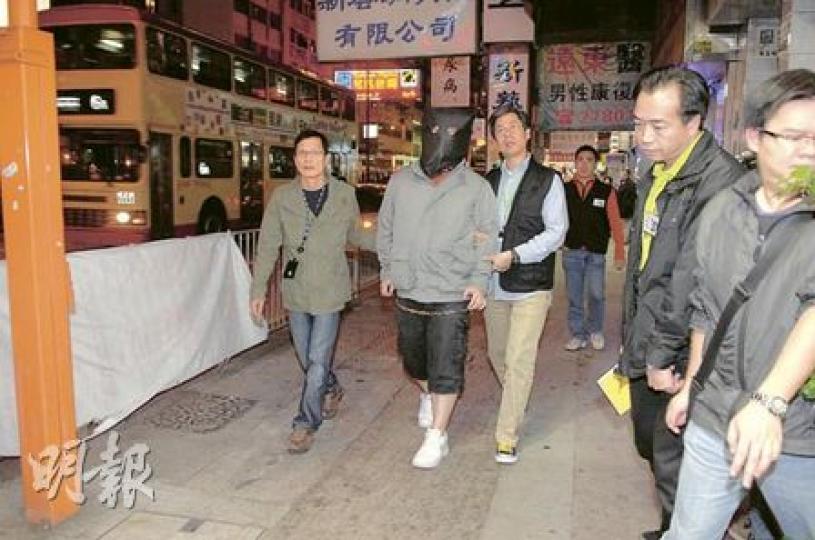 涉嫌於網上訛稱出售演唱會門票的男子，昨晚被探員黑布蒙頭押返旺角彌敦道一間網吧重組案情。（衛永康攝）