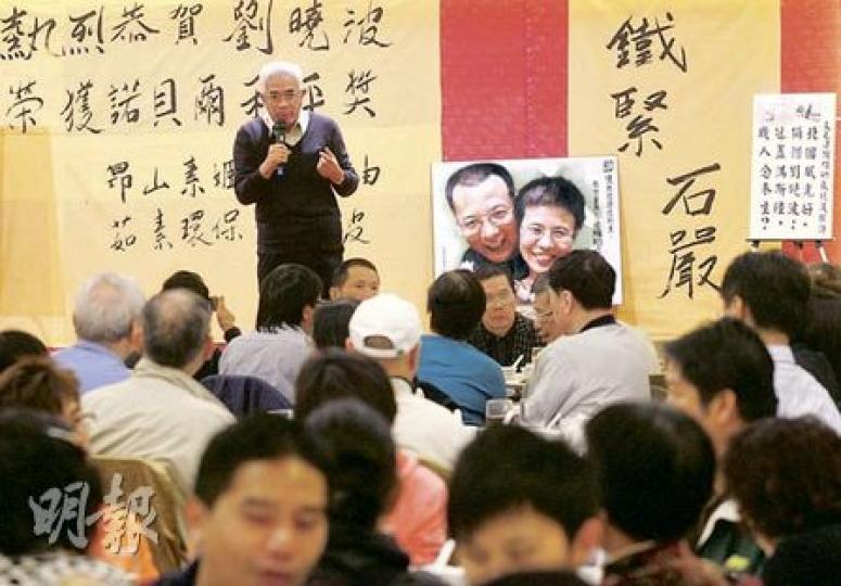 約700人昨晚在旺角一家酒樓出席「飯醉」晚宴，祝賀劉曉波獲得諾貝爾和平獎，資深傳媒人程翔站在劉曉波夫婦畫像前發言，說他堅信和平獎可以推動中國民主發展。（林振東攝）