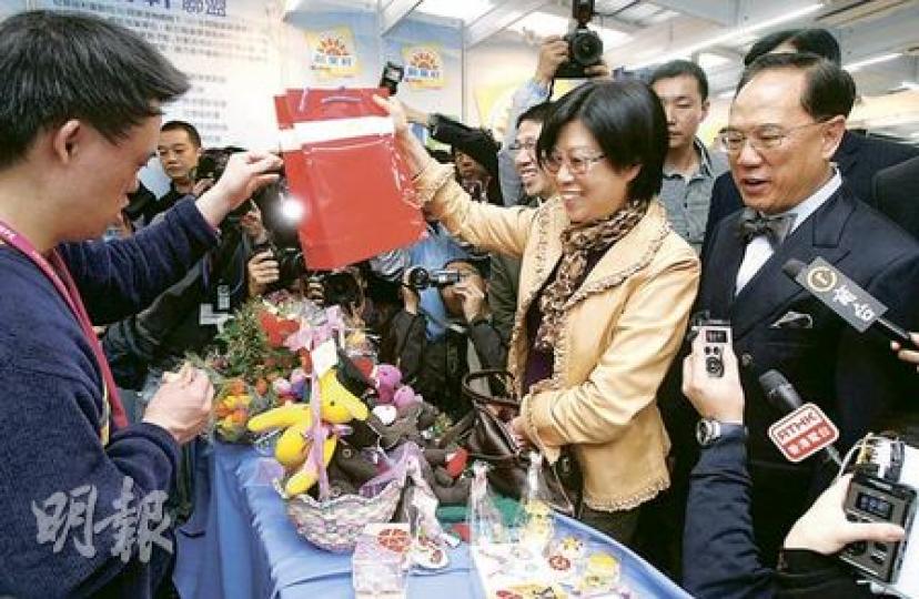 特首曾蔭權（右一）昨與太太（右二）逛工展會，短短十多分鐘便花了2030元買了烏冬、曲奇和相架等。（林振東攝）
