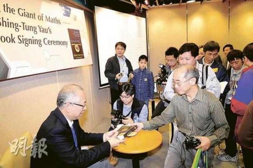 昨日有不少市民拿着新書排隊向丘成桐教授（左）索取簽名。（張智超攝）