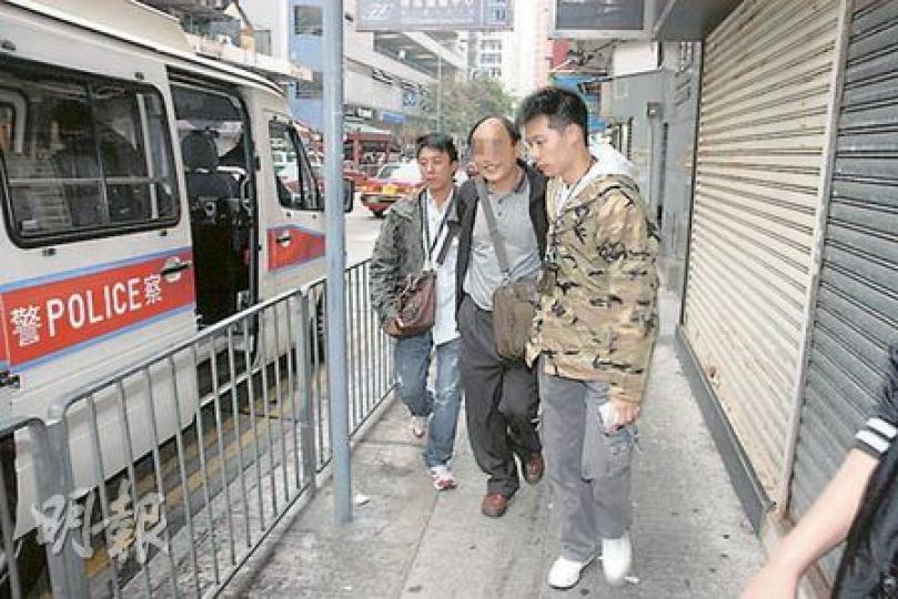 內地男子（中）來港追債不果，涉嫌動粗打傷他人被捕，由警員帶上警車時面露笑容。（何朝財攝）蕪湖街追債傷人事件，被指稱拖欠前生意伙伴100萬元男子，被人打傷送院治療。（何朝財攝）