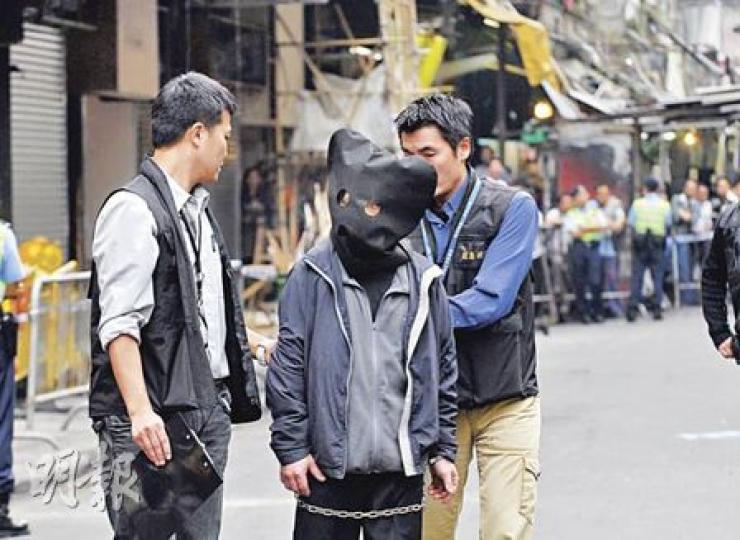縱火疑犯昨被帶到4個案發地點重組案情，不少街坊見疑犯出現即破口大罵。（梁琬珊攝）
