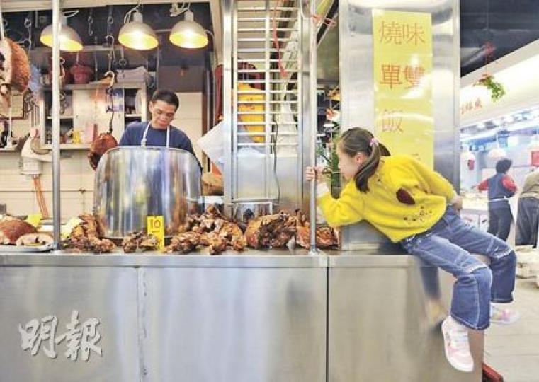 經過翻新的大元街市十分注重清潔，改變一般街市地面濕滑、不整潔的形象，圖中燒臘師傅的女兒坐在一旁窺看父親工作。（余俊亮攝）推出「買雞送雞」的鄭先生表示，昨日開店個多小時後，店內200多隻雞即告沽清，「若生意不好就不會賣光」。（余俊亮攝）