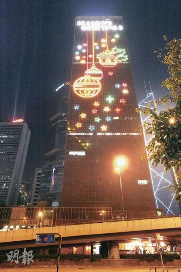 矗立在金鐘政府合署天台的香港飛龍燈飾以450支光管組成，長26米、高15米，每晚8至12時亮着。自02年7月運作至今，估計已花掉86.7萬元電費，相等於排放607公噸二氧化碳。（尹錦恩攝）燈飾大王黃劍山秘密練兵，已成功研製出以LED製作大廈外牆燈飾，可透過電腦控制顏色及圖案變化，有如大型屏幕，播放動畫亦不成問題。（馬耀森攝）