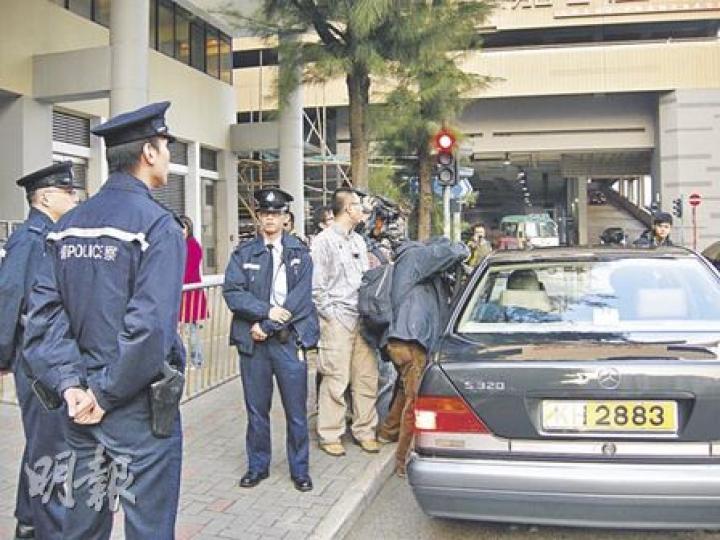 昨日法院門外有多名軍裝警員戒備，圖中私家車在午休時接載Amina離去，在眾目睽睽下於太安街的T字路口衝紅燈右轉，駛入愛勤道，幸好當時並無其他車輛和行人經過。（梁珮珊攝）