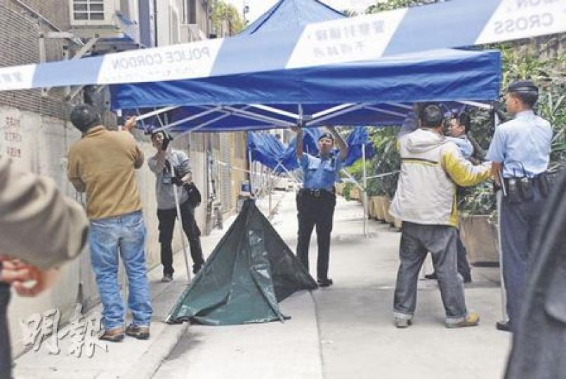 男子刀傷妻子後跳樓自殺，倒斃1樓平台的鋅鐵簷篷頂。消防架起雲梯將屍體移走，暫放於大廈後巷，並用帳篷遮蓋。（屈俊樂攝）探員在案發單位檢走兩個染血枕頭。（屈俊樂攝）