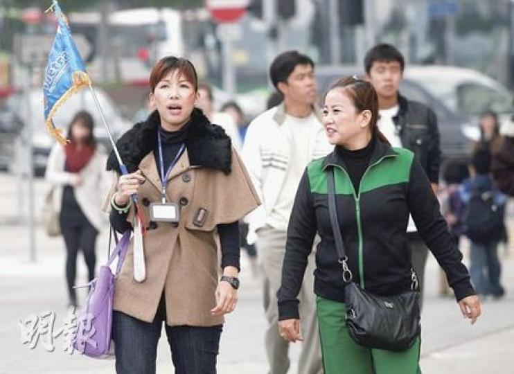 導遊總工會600名導遊原計劃聖誕罷工，抗議旅遊業議會實施「一團一導遊」，最終未能取得業界包括旅行社和店舖支持，行動暫擱置。圖為帶領內地團的導遊。（林振東攝）