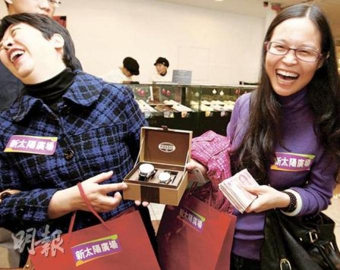 來自廣西的王小姐（右）一手拿着大疊現金，一手拿着新購的戰利品——一對共值1000元的情侶手表，她稱會把它們轉贈朋友。王小姐其後花約8000元購入一個名牌手袋及化妝品。（李紹昌攝）來自杭州的章小姐（右）與母親到港兩三日已花了8萬多元買首飾、名牌手袋、香水等，她預計明日離港時將花費共15萬元購物。（李紹昌攝）昨日聖誕節，大批市民及內地遊客前往尖沙嘴購物，廣東道一帶的名店更出現長長人龍。（李紹昌攝）