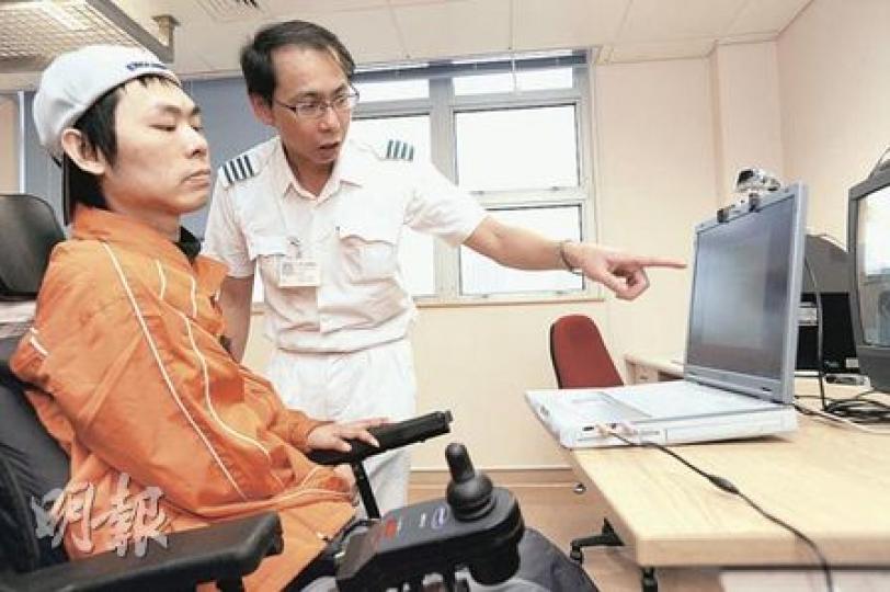 九龍醫院替癱瘓的陳先生（左）申請體恤安置，遷至環境較佳的公屋，單位內設有電腦控制的智能設備，方便日常生活。九龍醫院脊椎康復科一級職業治療師陳國強（右）教導他以頭部移動來控制家具，如開窗簾、關燈等。（何家達攝）