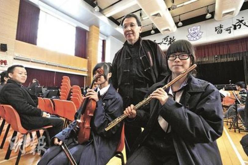 前規劃地政局長蕭炯柱（中）退而不休，去年創立青年音樂基金，助年輕人交流演出，今年更首執教鞭，教天水圍中學生拉小提琴，延續愛音樂生活。他指出，能夠看到年輕人投入音樂，十分欣慰，亦希望從中教曉他們做人道理。（余俊亮攝）蕭炯柱自2001年退出官場後，到中學教學生拉小提琴，與妻子黃樂怡（右）享受第二人生。（余俊亮攝）