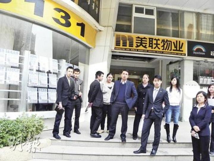 位於深圳市南山區的美聯物業海月第二分行10名職員走出店門，阻止記者在店外訪攝，稱私人地方不可拍照，記者不欲爭拗轉身離去，卻遭兩名男職員阻止，二人（左五及左七）更趨前用腳連環踢向在場的兩名記者。（明報記者攝）圖為踢記者的兩名美聯職員，站後方的職員其後被帶返公安派出所接受調查。（明報記者攝）