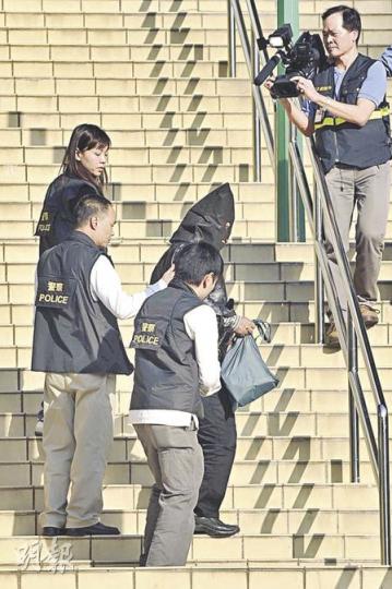 警方昨午將芭蕾舞學校校長徐滿芬劫殺案的疑匪，押返現場重組案情。過程中只見疑犯從扮演死者的女探員手上「扯走」手袋，並無作出扑頭動作。（余俊亮攝）