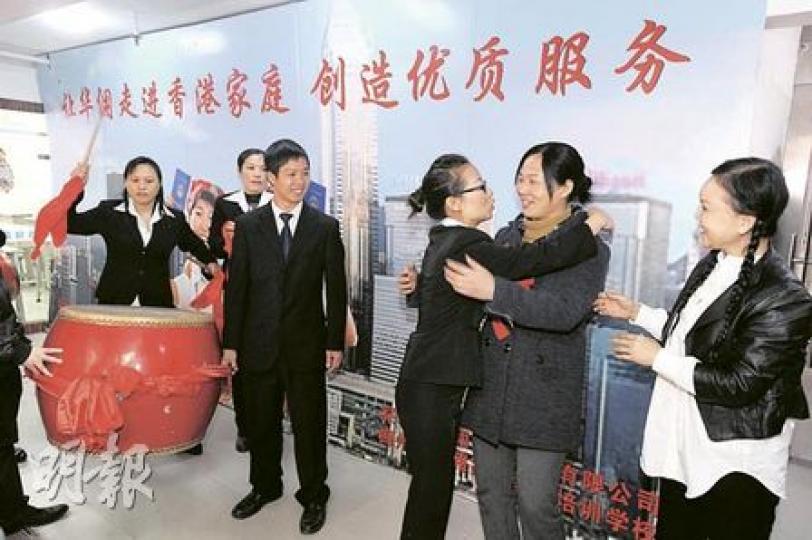 深圳市中家職業技能培訓學校，昨打鑼鼓歡送學員徐青玲（右二）來港，會場上列出「讓華傭走進香港家庭，創造優質服務」口號造勢。（尹錦恩攝）