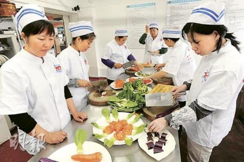除了「月嫂」，深圳中家家庭服務公司亦安排一般家傭學員學習烹飪，規定入廚必須穿整齊制服。（尹錦恩攝）