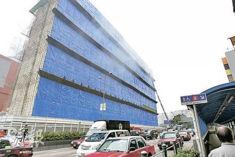 廣東道前政府合署發生三級火，消防員拉開圍着大廈的膠布，以助濃煙散去。（黃雄攝）