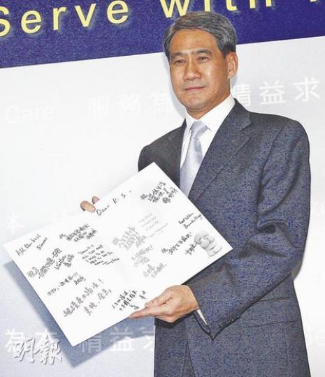 下周退休的鄧竟成，昨日從一班記者手上接過心意卡就急不及待打開，笑言﹕「看一下你們有什麼說話講」。（李紹昌攝）