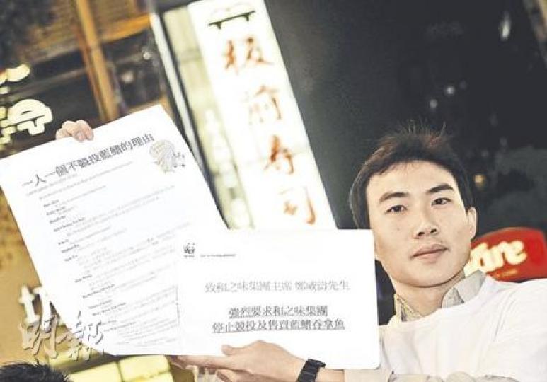世界自然基金會代表昨日將超過280個於facebook群組收集的「一人一個不競投藍鰭的理由」，交予和之味集團轄下位於旺角的板前壽司店。（余俊亮攝）
