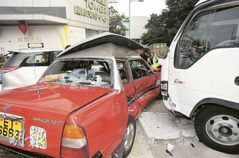 交通意外中，的士如三文治被中型貨車及七人房車夾住，司機一度受傷被困待救，幸傷勢不嚴重。（樊銳昌攝）的士右邊車身先遭中型貨車攔腰撞至嚴重凹陷，繼而被推入對行線與駛至七人房車相撞釀成三車「串燒」。（樊銳昌攝）