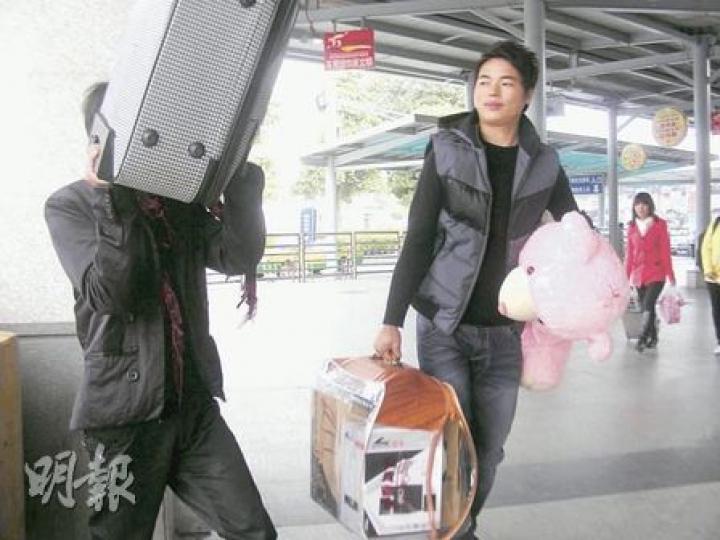 民工小周抱着預備送給女友的熊公仔提早回鄉過年。(李泉攝) 民工小周抱着預備送給女友的熊公仔提早回鄉過年。(李泉攝)