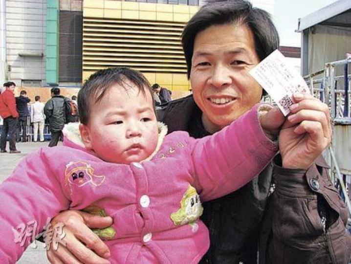 周振明(右)抱著女兒,一家人將踏上20小時無座位的旅程。(林迎攝) 周振明(右)抱著女兒,一家人將踏上20小時無座位的旅程。(林迎攝)
