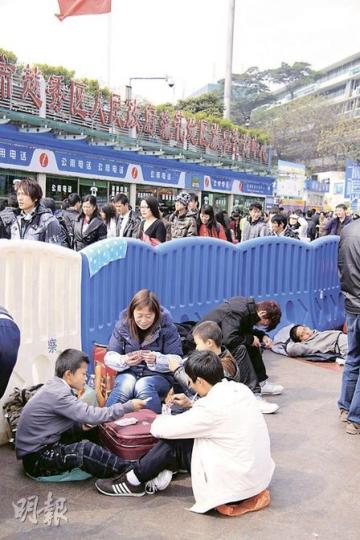 不少旅客表示,陰雨天氣令候車環境舒服了很多。圖為候車一家大小在玩撲克消磨時間。(麥俊攝) 不少旅客表示,陰雨天氣令候車環境舒服了很多。圖為候車一家大小在玩撲克消磨時間。(麥俊攝)