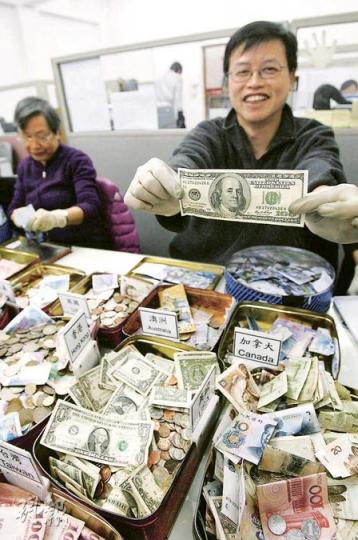 UNICEF每周3天安排義工,分類各種收集到的外幣零錢,義工發現大額鈔票時都不禁起哄歡呼。(林振東攝) UNICEF每周3天安排義工,分類各種收集到的外幣零錢,義工發現大額鈔票時都不禁起哄歡呼。(林振東攝)