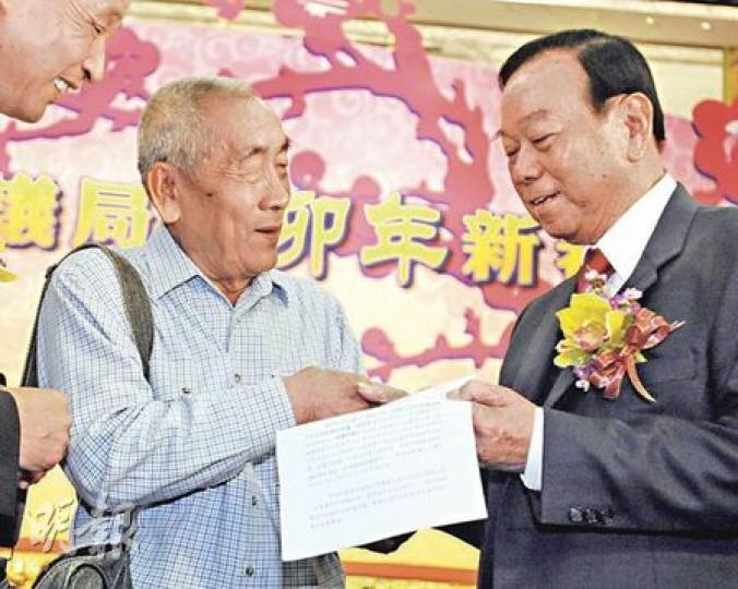 鄉議局主席劉皇發(右)昨宣布菜園新村的路權問題已解決,並即場把有關道路使用權信件交給菜園村村民代表葉伯。(朱永倫攝) 鄉議局主席劉皇發(右)昨宣布菜園新村的路權問題已解決,並即場把有關道路使用權信件交給菜園村村民代表葉伯。(朱永倫攝)