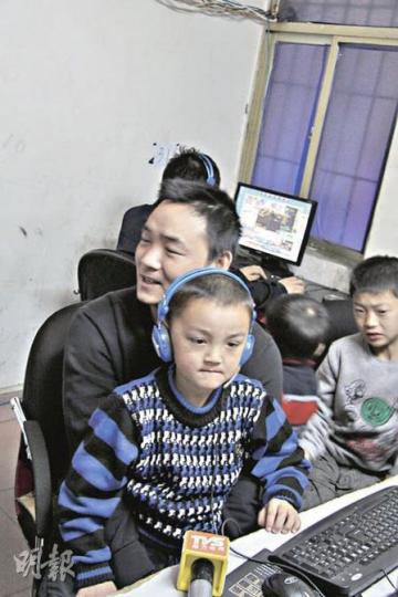 彭高峰一家四口就住在網吧內的閣樓上。圖為彭高峰上周四在深圳抱着兒子接受媒體採訪。(麥俊攝) 彭高峰一家四口就住在網吧內的閣樓上。圖為彭高峰上周四在深圳抱着兒子接受媒體採訪。(麥俊攝)