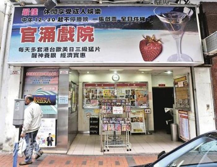 為扭轉劣勢，官涌戲院先後推「一張戲票，全日任睇」及長者優惠，實行買一送一，可惜仍不敵貴租及最低工資，將於3月結業。（余俊亮攝）官涌戲院談不上有何裝修，更沒有一部像樣的放映機，投影機播出的影片質素比家中電視還差，負責人形容這處為大排檔，是基層街坊的聚腳點。（余俊亮攝）官涌戲院為前舖後院，地舖門前放着貨架，掛滿二手色情光碟和影帶，全是戲院的落畫片。（余俊亮攝）