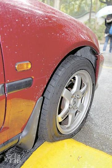 屯門良景邨30部泊在路邊的車輛輪胎遭放氣，可看到被放氣的車胎明顯扁平。 （屈俊樂攝）
