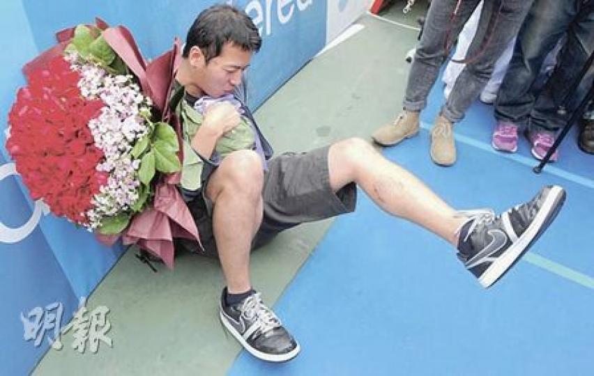 阿成於終點準備送花求婚，卻不見愛人蹤影，更不小心跌倒地上。（劉焌陶攝）