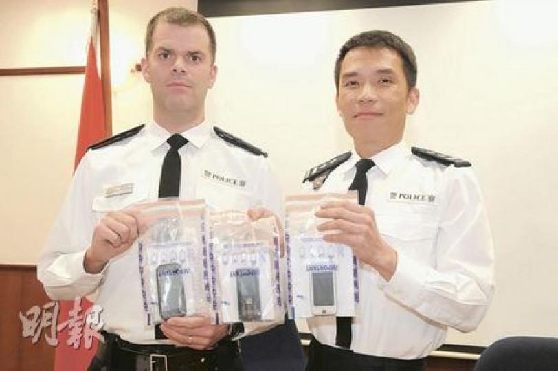 警方拘捕6名專搶手機青少年，九龍城分區特遣隊主管鍾啟榮（右）展示起回的手機，呼籲市民財不可露眼。（衛永康攝）