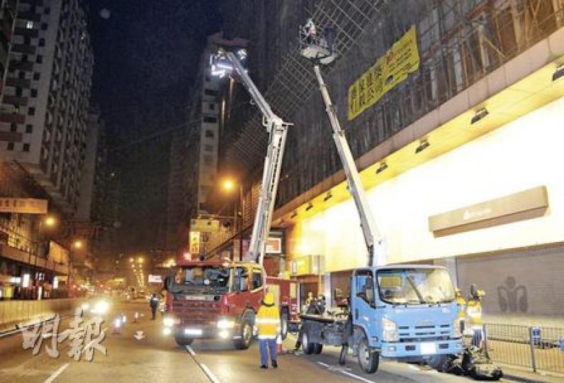 消防員架起雲梯拯救困在工程車升降台的2名工人。（蔡方山攝）被困升降台的工人，由消防員到場架雲梯救下。（蔡方山攝）涉事工程車司機，遭警員警誡。（蔡方山攝）
