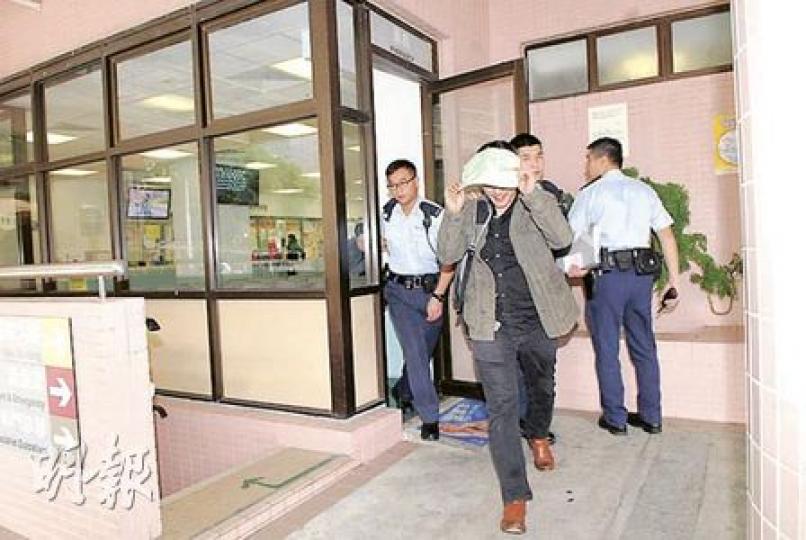 涉嫌自殘及刑事毁壞的尼泊爾男子（左二），事後由警員帶走，送院檢查傷勢，離開時以紙遮面。（梁琬珊攝）